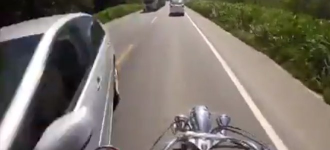 Un motard évite une voiture qui arrive en face